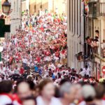 Pamplona, Spain - July 9, 2013: People run from bulls on street Santo Domingo during San Fermin festival in Pamplona